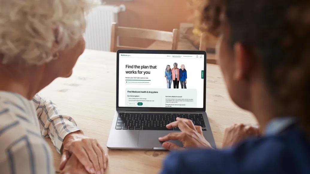 Two older women looking at the Medicare website on a laptop screen