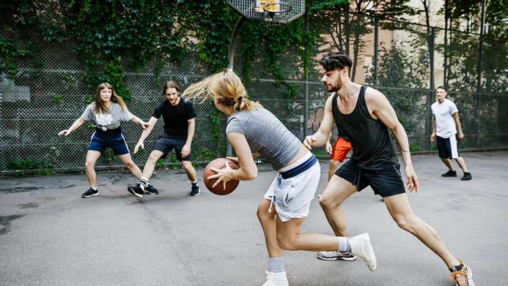 Men and women playing basketball