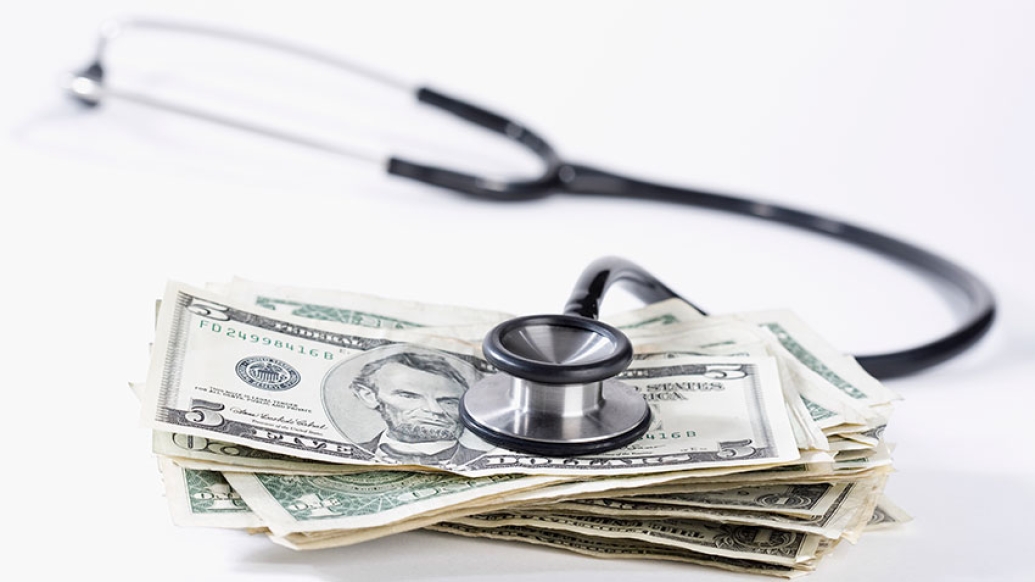 Stethoscope resting on a pile of money