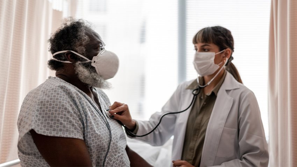 black man getting checked by doctor with masks on 