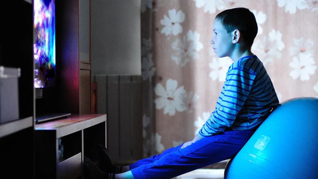 child sitting exercise ball tv