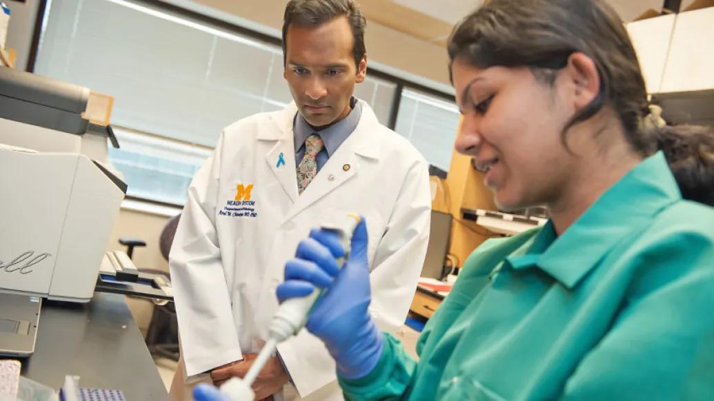 doctor and researchers in lab coat and white coat in lab looking at syringe injection