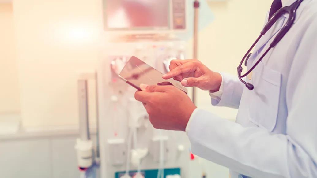 doctor holding tablet hospital room with stethoscope