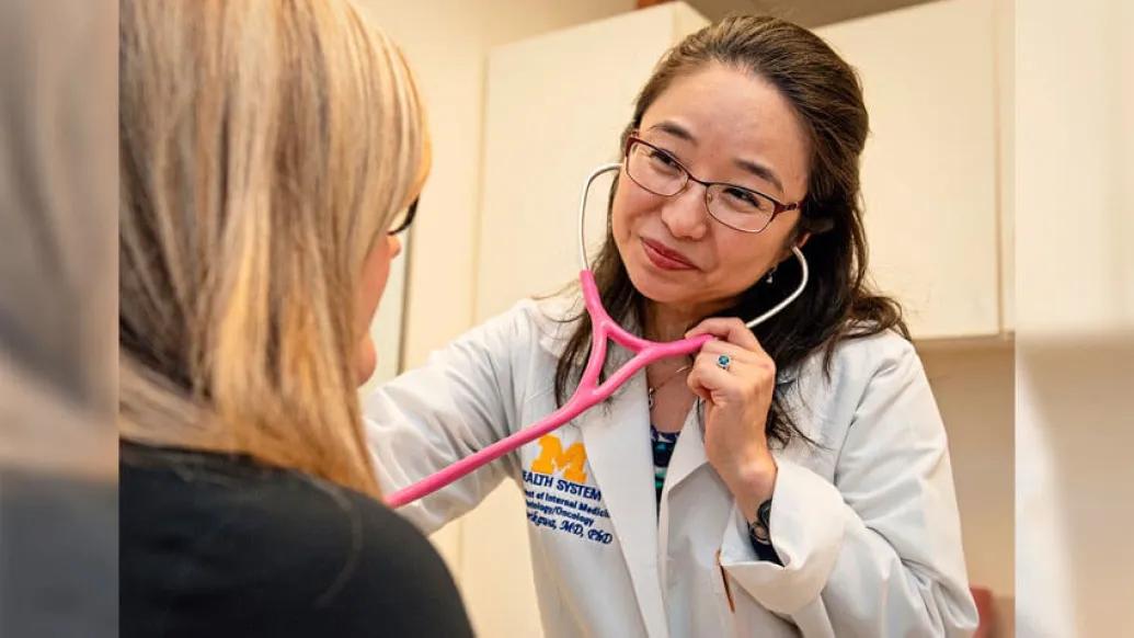 Doctor in whitecoat giving an exam with stethocope on patient
