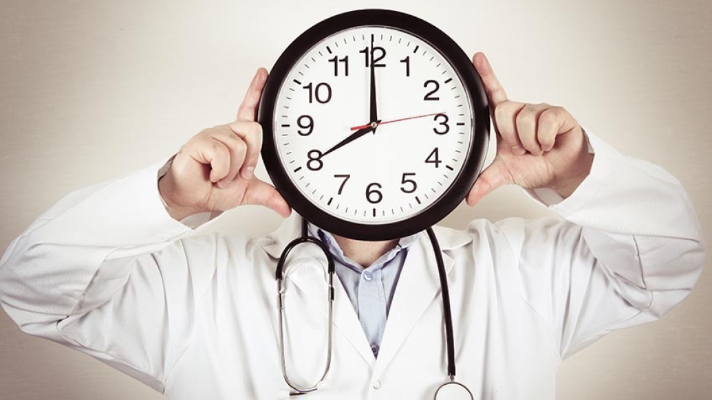 physician holding clock for head