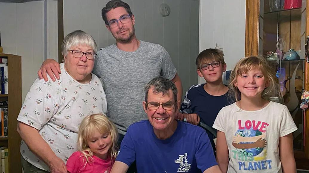 Family smiling with children at table