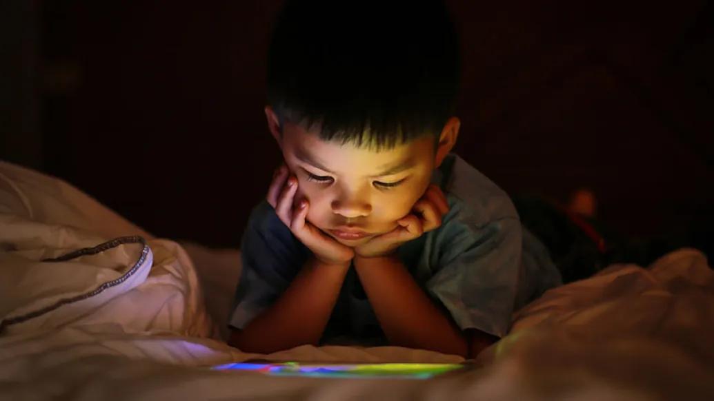 Child with ipad in bed