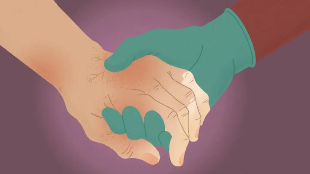 Patient holding hand with doctor wearing medical glove