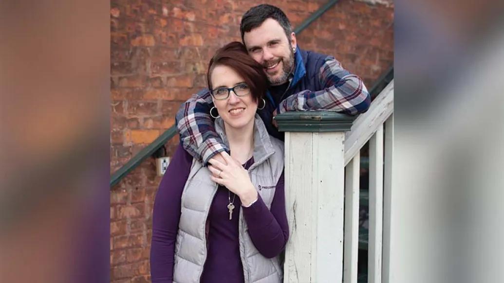 Husband and wife outside holding hands