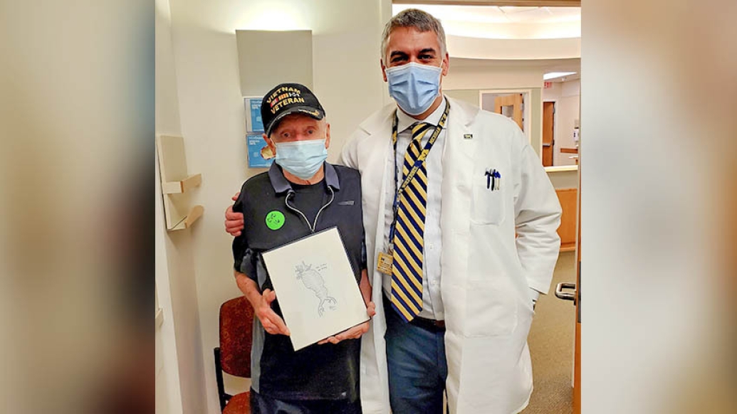 doctor and patient standing together holding the drawing