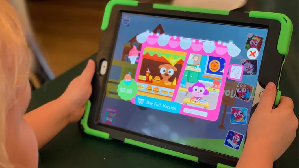 kid holding ipad with games on it