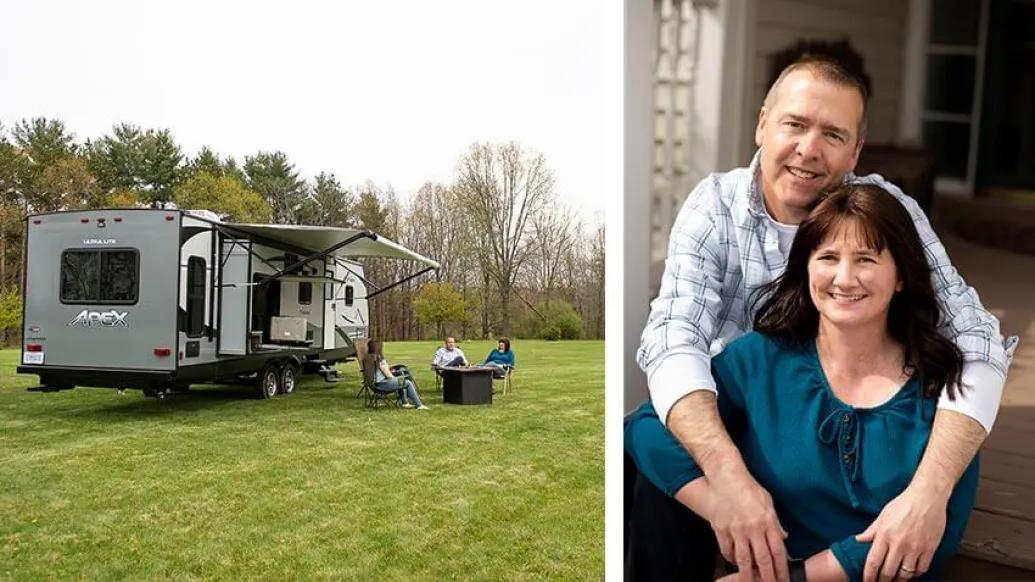 Man leaning over woman hugging and smiling near camper