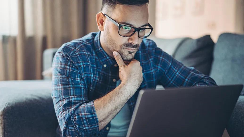 man worried looking at laptop