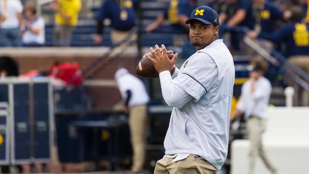 Michigan football player throwing football