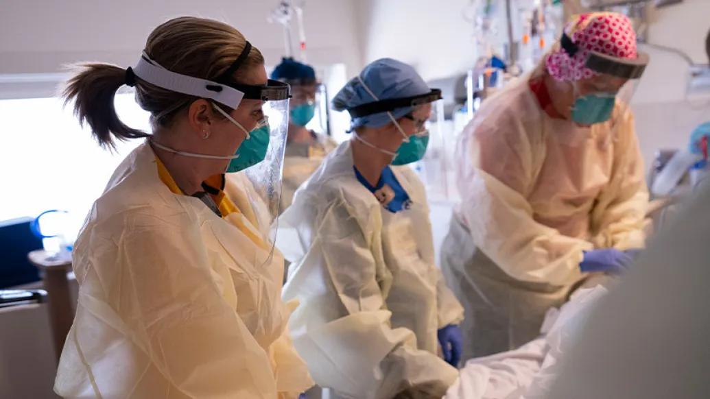 nurse team by bedside with covid patient