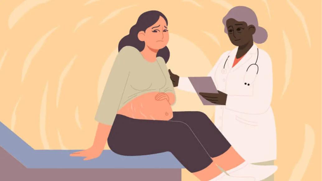 Pregnant woman sitting on edge of hospital bed talking with doctor