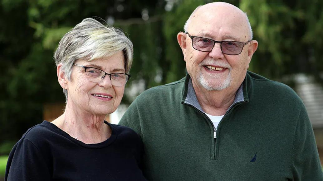 Senior couple standing outdoors smiling
