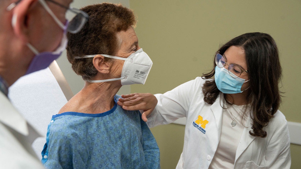 Providers looking over patient wearing masks