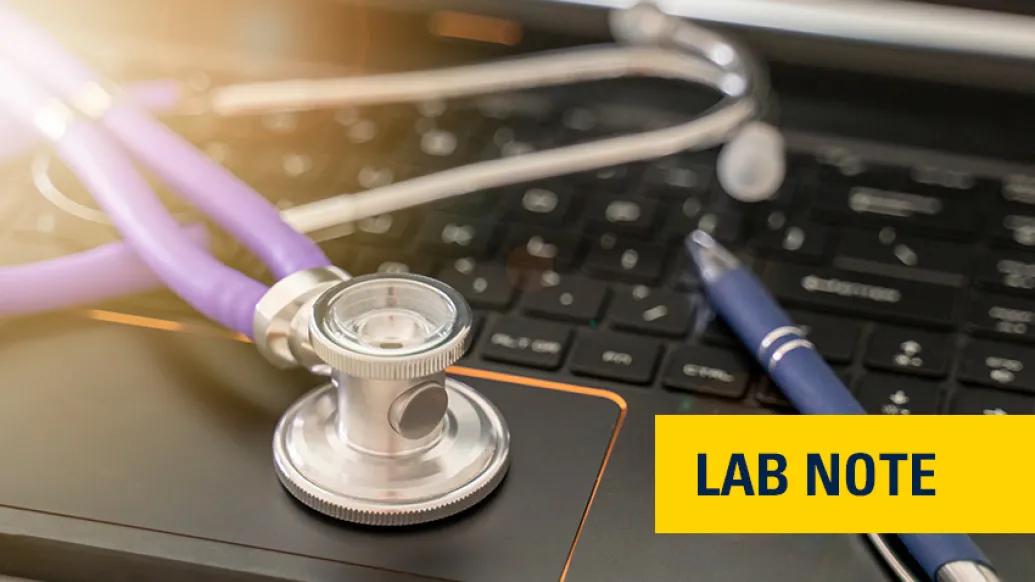 stethoscope black laptop keyboard pen with light in left corner
