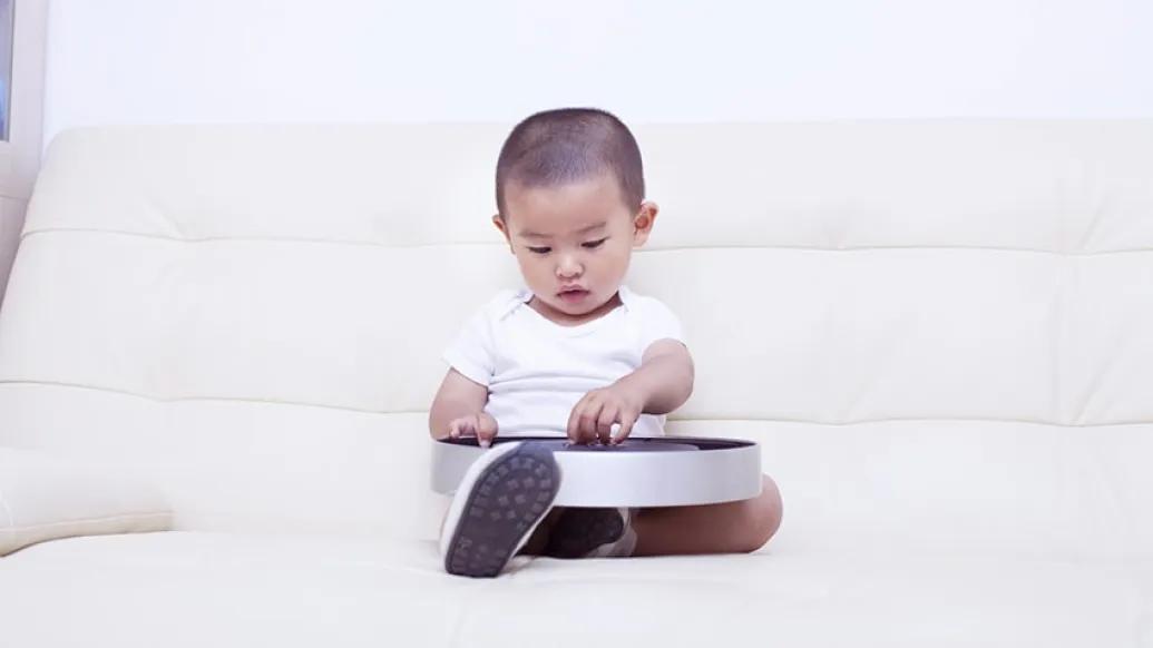 Child playing with a clock containing button batteries
