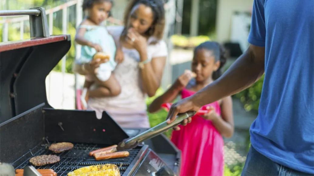 two kids outside barbequing with parents