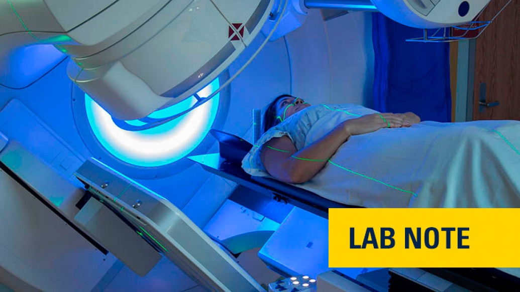 woman in hospital gown going under scan machine in blue light
