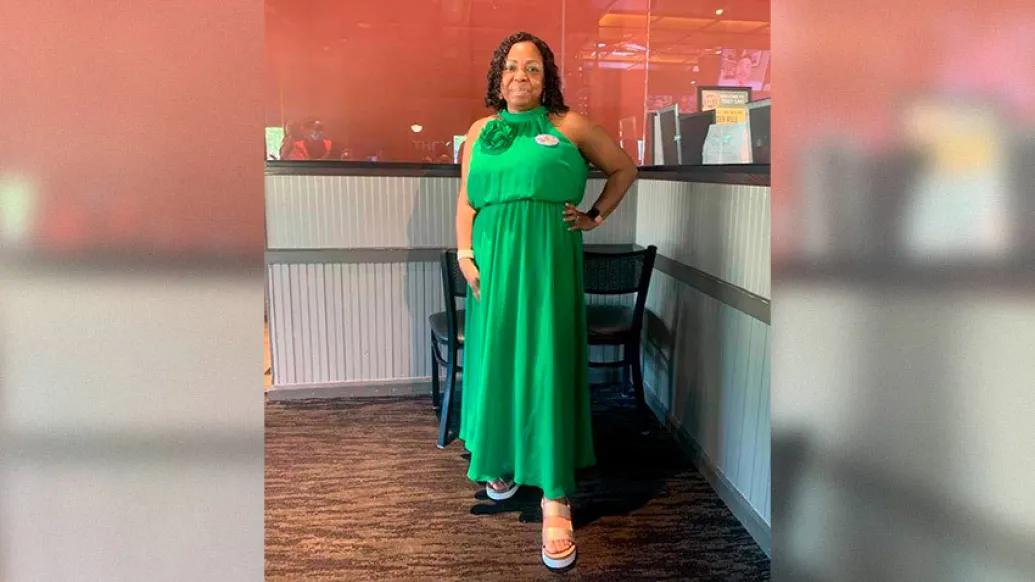 woman standing posing in green silk formal dress