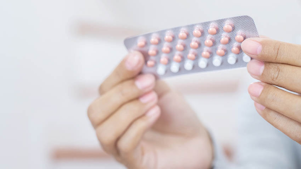 Woman hands opening birth control pills