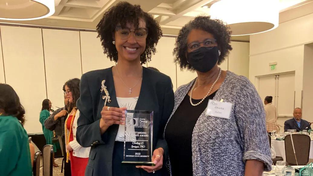 women smiling holding award conference 