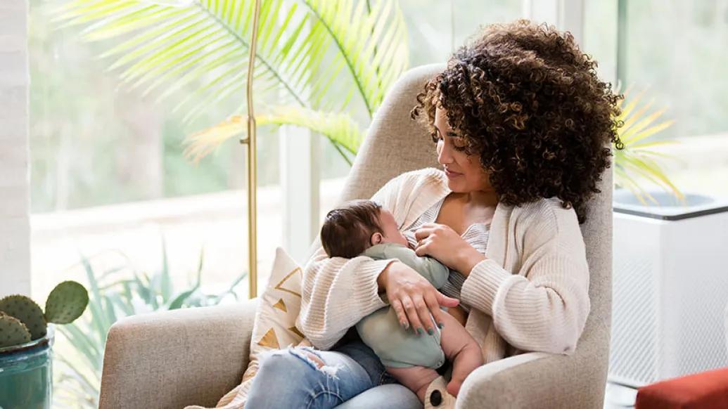 Women holding newborn in rocking chair
