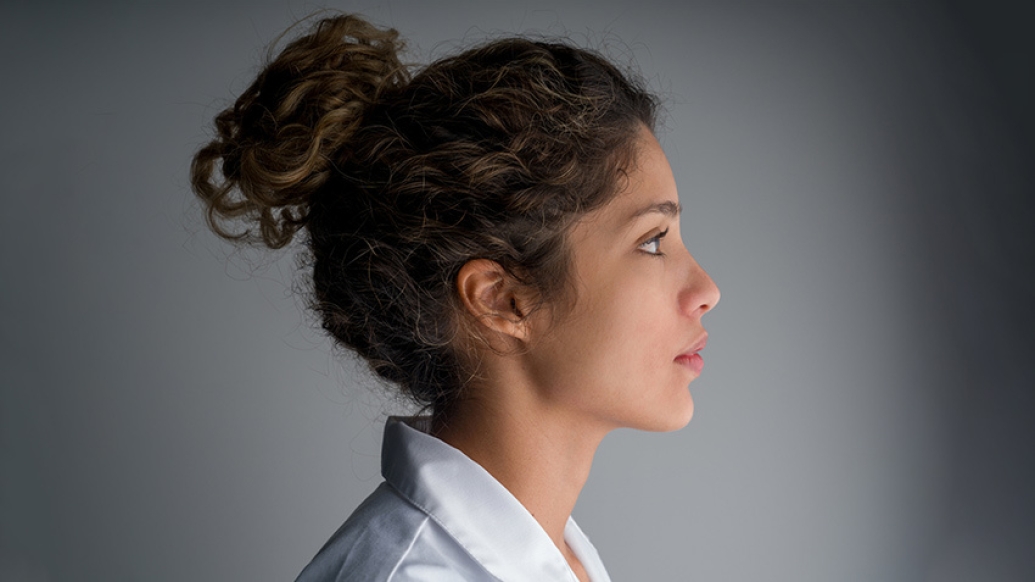 young woman doctor anxious worried side view with hair up white coat