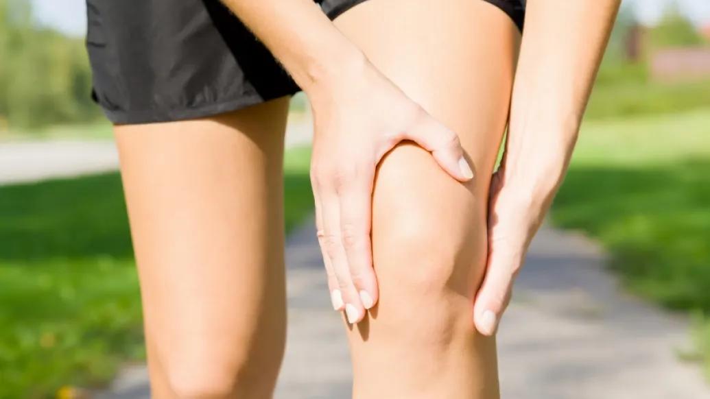 Woman in shorts holding her knee