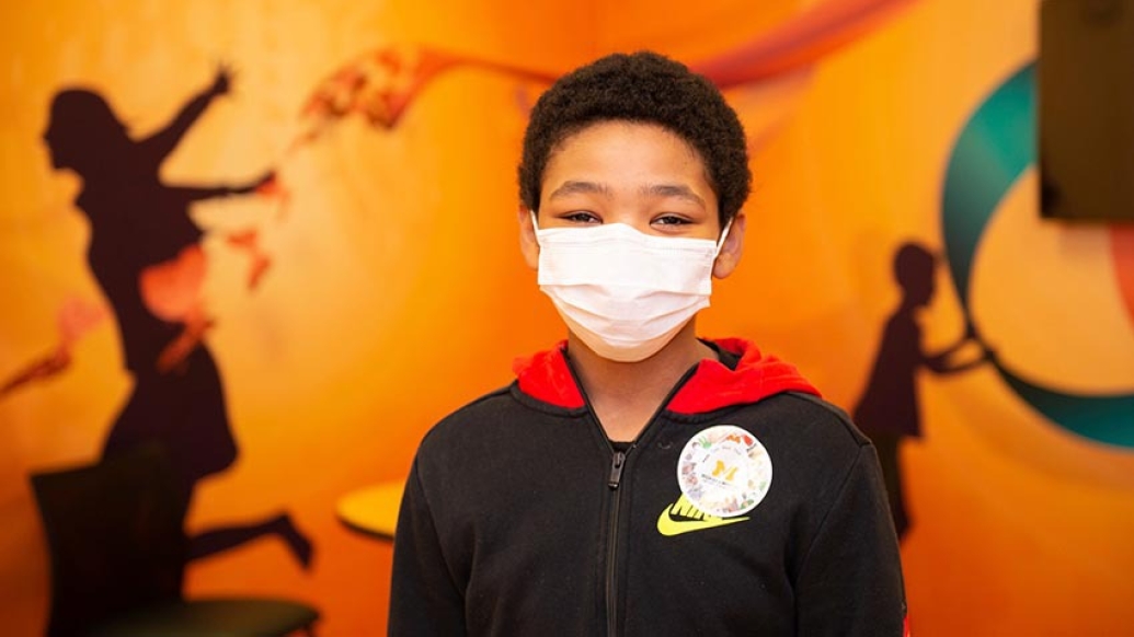 child in hospital with mask on and orange background