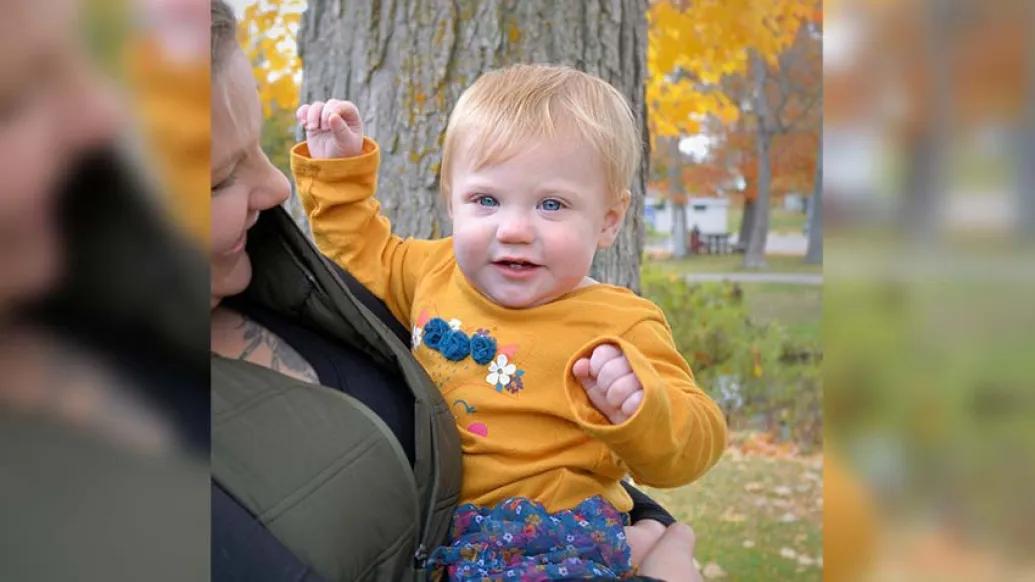 child in moms arms with yellow shirt on 
