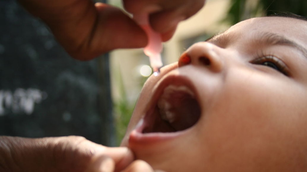 child receiving polio vaccine drops