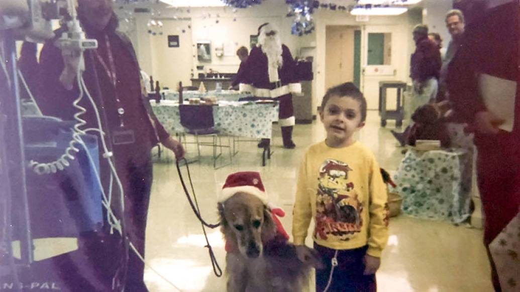 child standing with dog in hospital yellow shirt