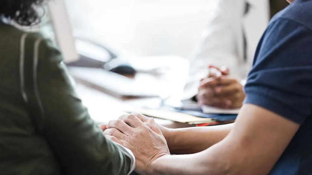 couple holding hands at doctor's office
