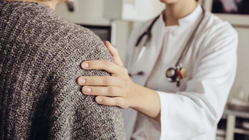 doctor's hand on patient's shoulder