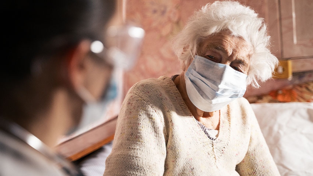 older woman sitting with healthcare worker