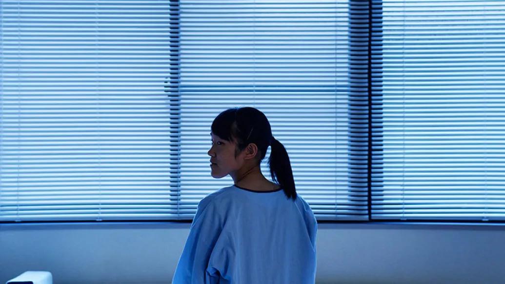 girl in room looking back grey