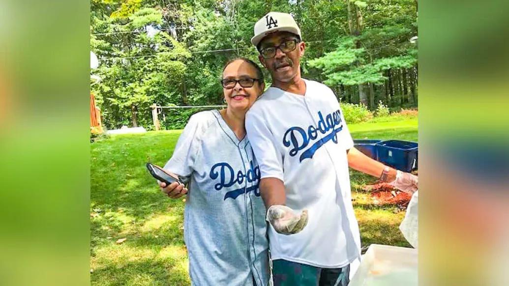 Husband and wife cooking out with their baseball shirts on