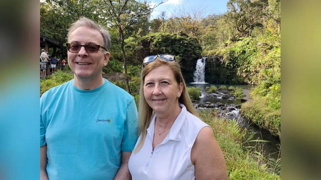 husband and wife near a waterfall