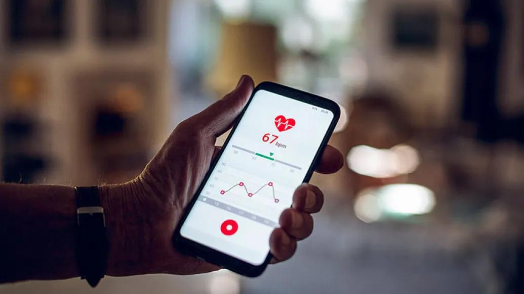 Man holding cell phone with heart rate app showing
