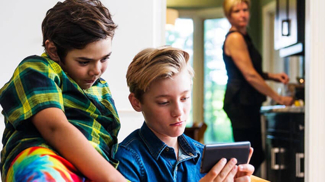 Parent looking concerned at children watching phone screen a lot