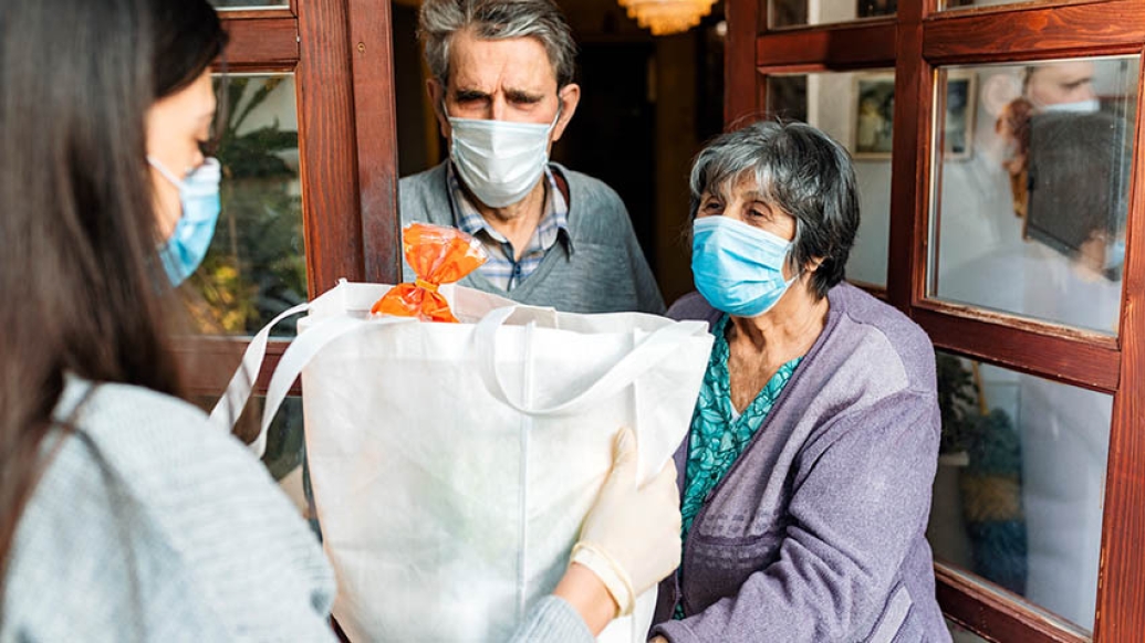 person delivering forceries to elderly couple