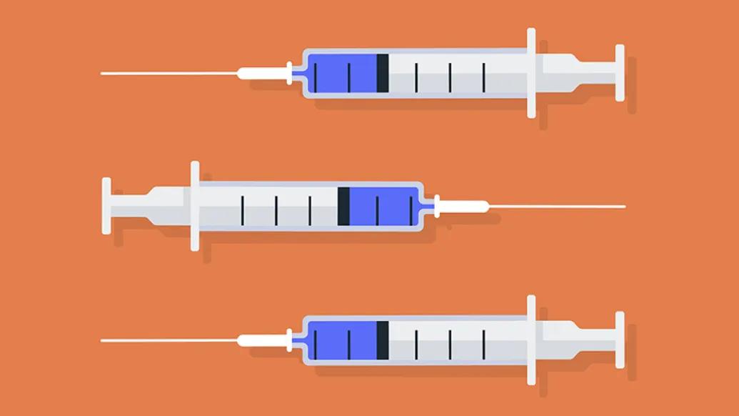 Three syringes with vaccine on orange background