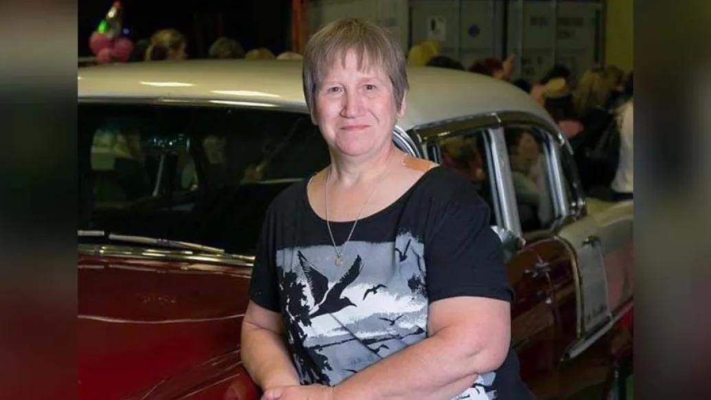 Woman standing in front of classic car