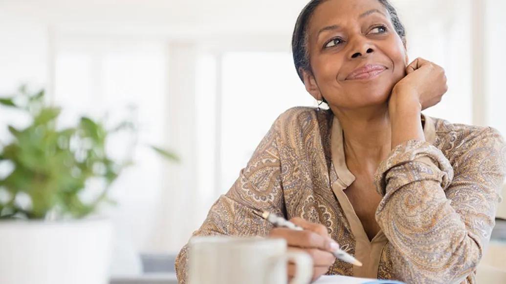 Woman staring in distance with a pencil in hand
