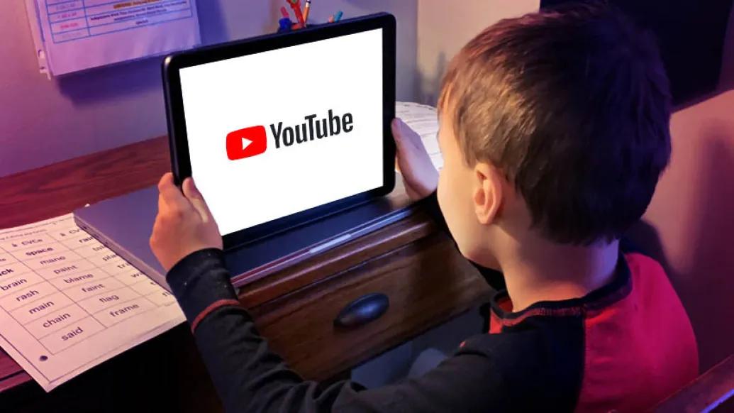 kid sitting watching youtube on tablet screen