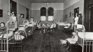 Children sit in bed or play a game in the Palmer Children's ward of the hospital